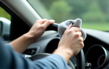 Person cleaning car windshield